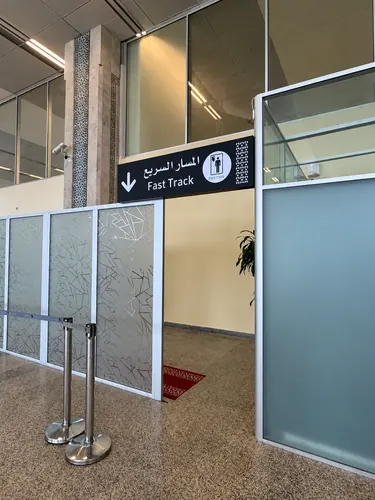 Panneau directionnel Fast Track en arabe et en anglais dans un aéroport
