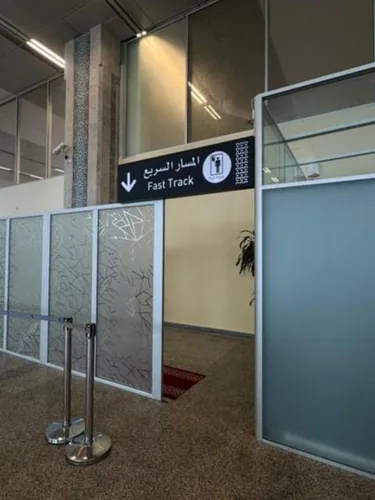 Panneau directionnel Fast Track en arabe et en anglais dans un aéroport