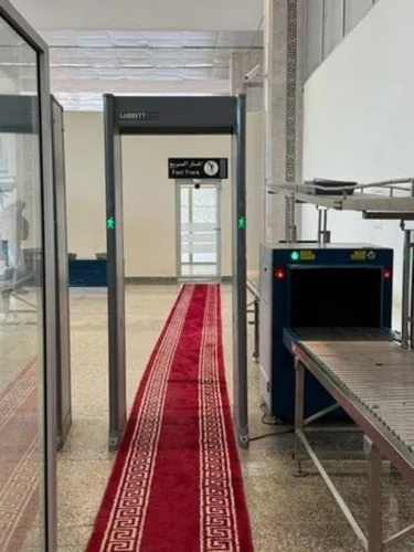 Équipements de contrôle de sûreté avec un panneau Fast Track à l’arrière-plan